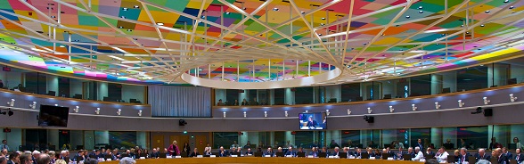 In the Europa building, a meeting is underway in the main meeting hall with its brightly coloured ceiling. The Europa building hosts EU summits, multilateral summits, ministerial meetings and other high-level meetings.