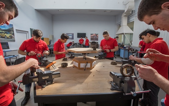 Young trainees working together at a workbench.