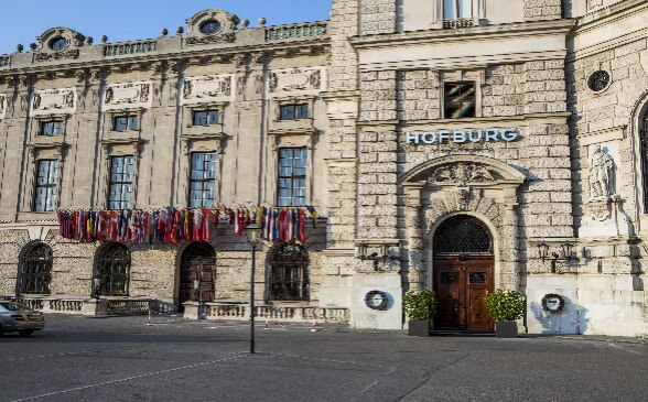 L'ingresso principale dell'OSCE all'interno del complesso di Hofburg decorato con bandiere.