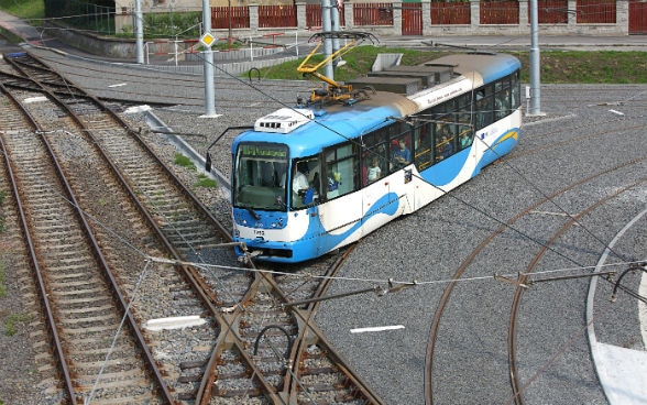 Ein Tram fährt über Schienen.