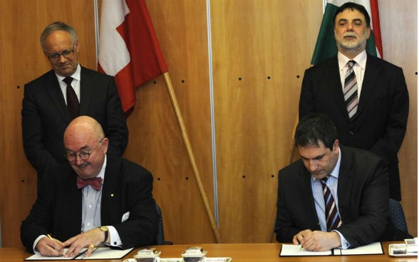 L’ambasciatore svizzero in Ungheria, Christian Mühlethaler, e il vicepresidente dell'agenzia nazionale dello sviluppo, Lóránt Lehrner, firmando gli accordi di progetto.