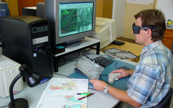 Un homme analyse une carte sur un écran d’ordinateur