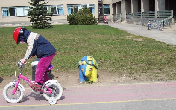 Velofahrendes Kind vor Schulgebäude in Rakvere