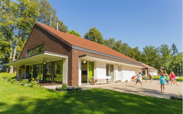 Des enfants jouent dans le jardin devant une maison 