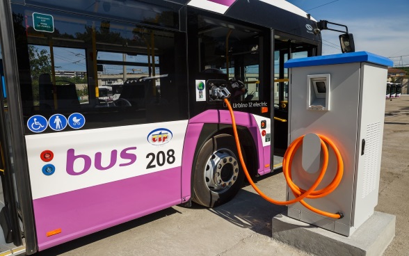 Passeggeri alla fermata in attesa di un autobus elettrico 