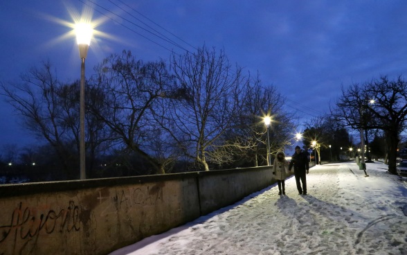 Due pedoni su un percorso illuminato