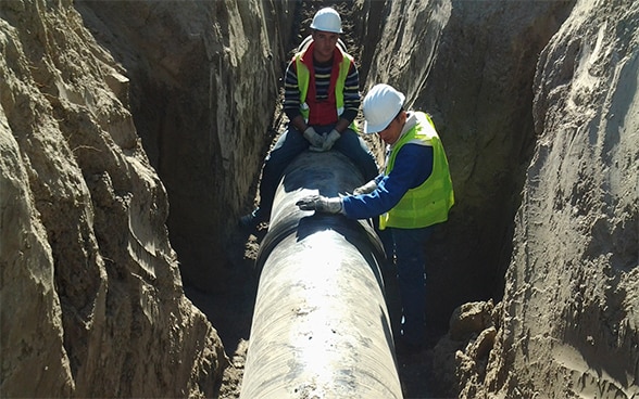 Deux ouvriers travaillent sur une conduite