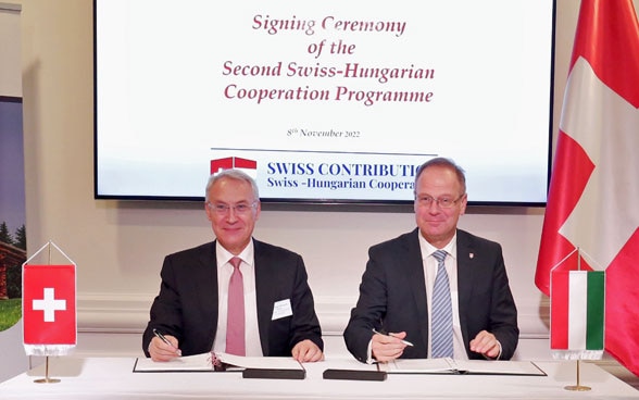 Der Schweizer Botschafter Jean-François Paroz und der ungarische Minister für Regionalentwicklung, Dr. Tibor Navracsics, unterzeichnen das Rahmenabkommen für das neue schweizerisch-ungarische Kooperationsprogramm; Budapest, 8. November 2022.