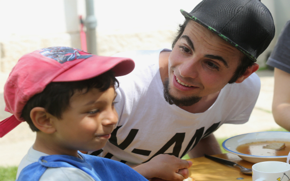 Ein junger Mann und ein Junge beim Essen im Kinderheim PeCA. 