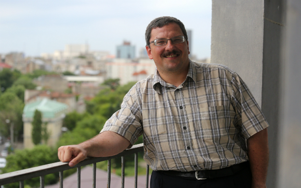 The Swiss national Pascal Praz, Swiss chair of the Opération Villages Roumains - Suisse association, standing on a balcony.