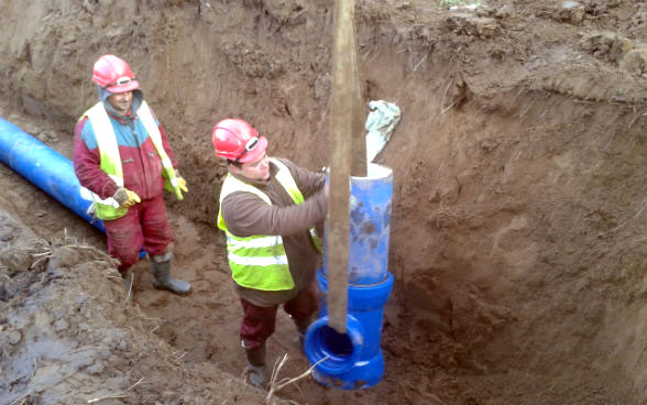 Zwei Männer verlegen eine neue Wasserleitung