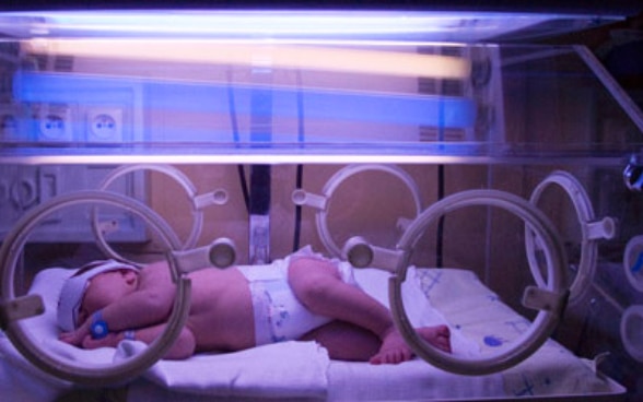 Un nouveau-né sous la lumière de tubes fluorescents 