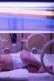 A newborn under a fluorescent lamp
