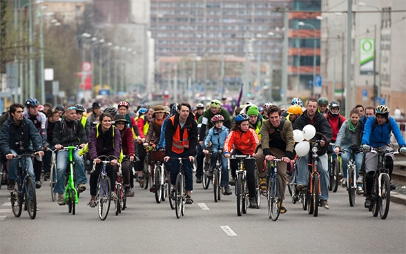 Un cospicuo gruppo di ciclisti partecipa a una campagna per il traffico lento. 