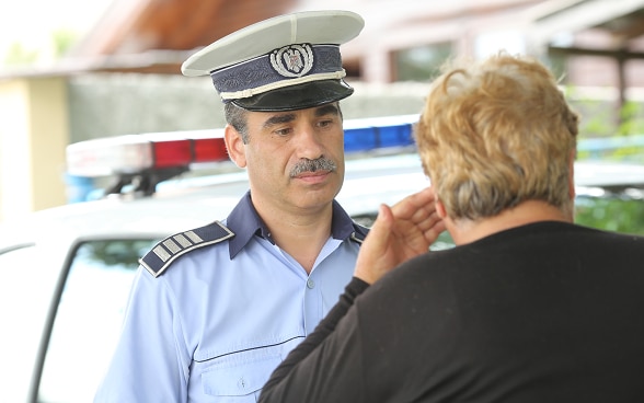 Polizist hört einer Frau zu.